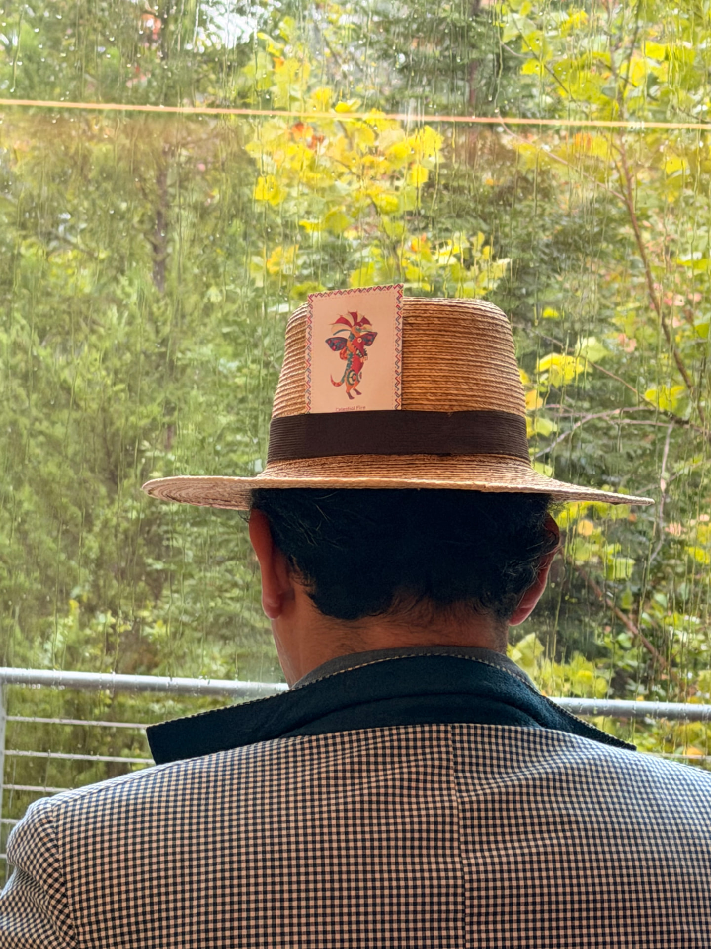 Participante con sombrero tejido mirando hacia los árboles