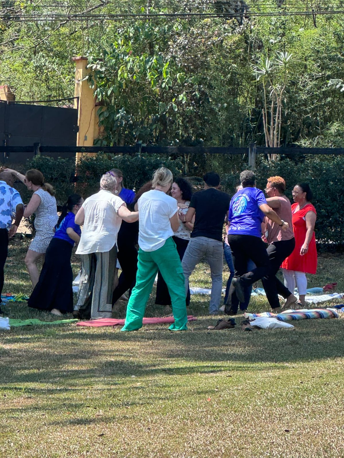 People moving and dancing together on the grass in a garden