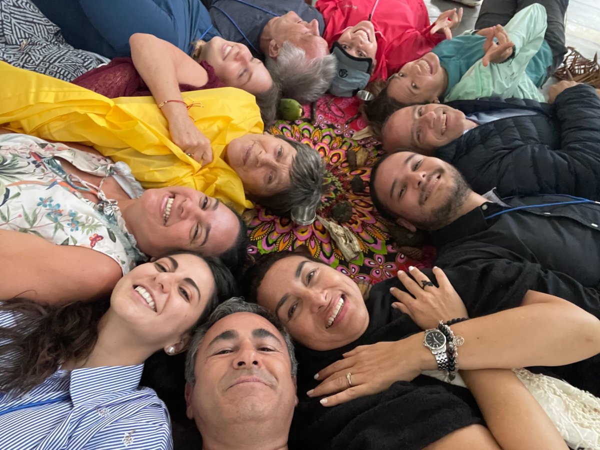 Participants lying in a circle with their heads together, smiling upward