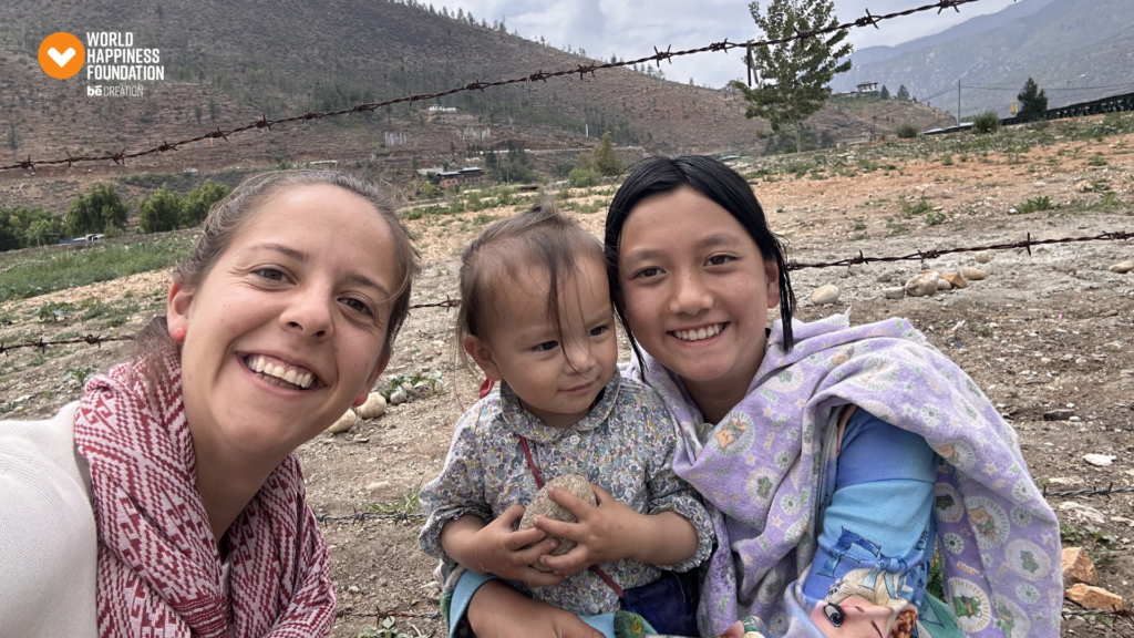 Traveller smiling with two Bhutanese children in the hills
