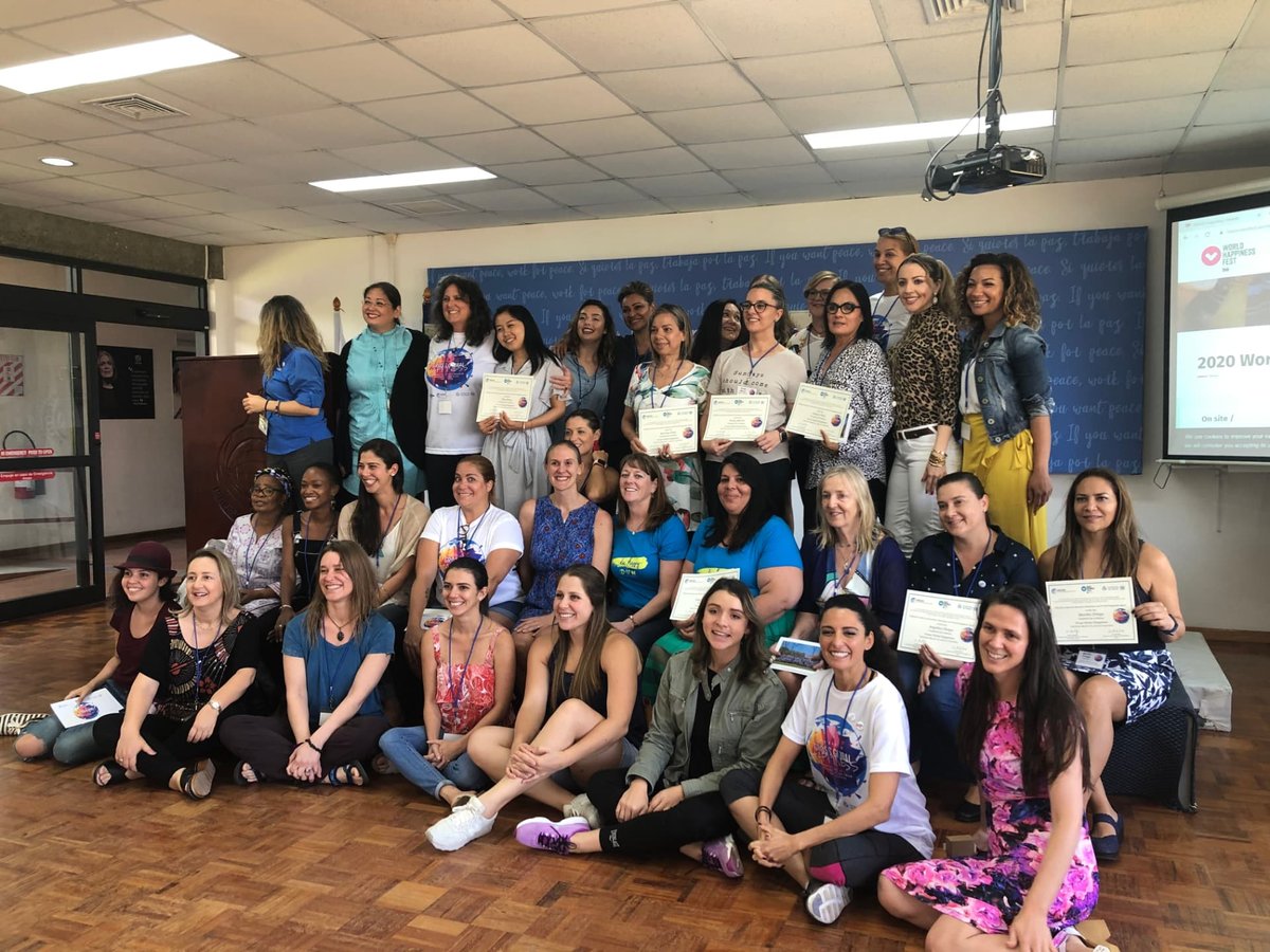 Group of participants holding certificates after a World Happiness Academy programme