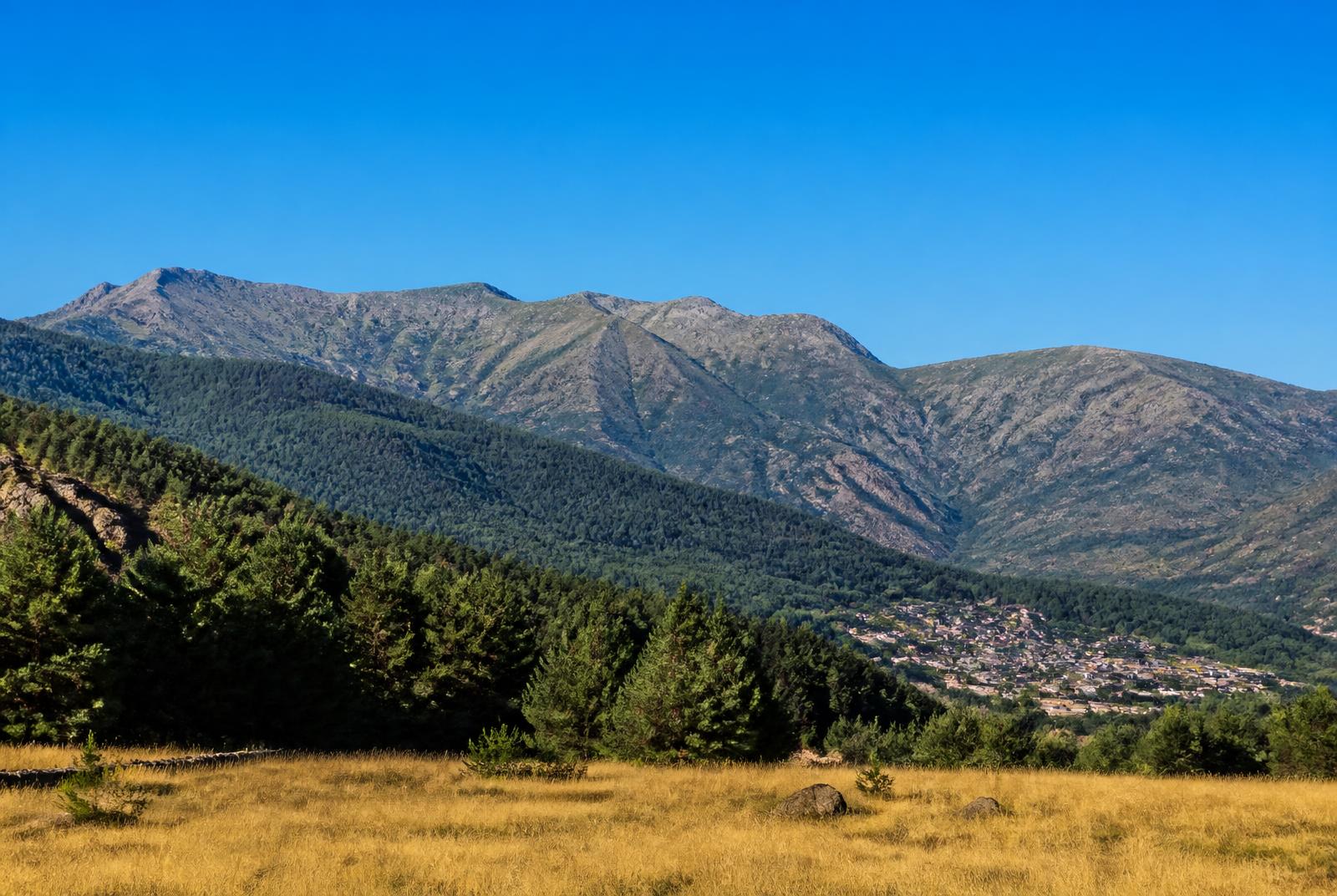 La Sierra de Guadarrama sobre un pueblo de la sierra de Madrid.